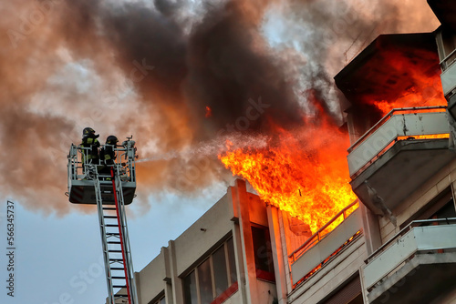 Italian firefighters at work during a fire in an attic of a building in an Italian city. Apartment on fire and flames. 