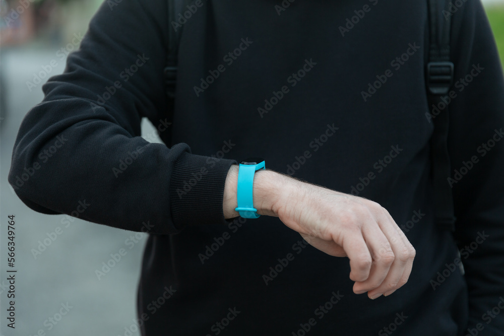 Fototapeta premium Sport man looking smart watch at modern track runner using use smartwatch fitness bracelet, fit male athlete checking result jogging in sportswear in street urban city park outdoor