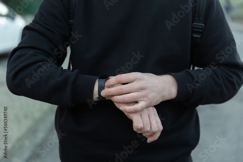 Sport man looking smart watch at modern track runner using use smartwatch fitness bracelet, fit male athlete checking result jogging in sportswear in street urban city park outdoor