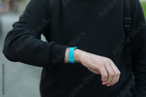 Sport man looking smart watch at modern track runner using use smartwatch fitness bracelet, fit male athlete checking result jogging in sportswear in street urban city park outdoor