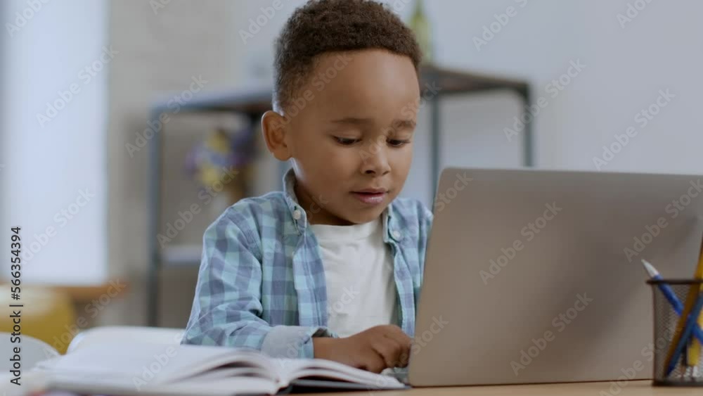Kids and technologies. Little black boy pushing buttons on laptop keyboard, daddy coming and fixing mistakes, free space Kids and technologies. Little black boy pushing buttons on laptop keyboard, daddy coming and fixing mistakes, free space