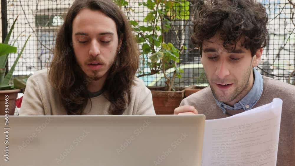 work together - young men translating a text together on the computer work together - young men translating a text together on the computer