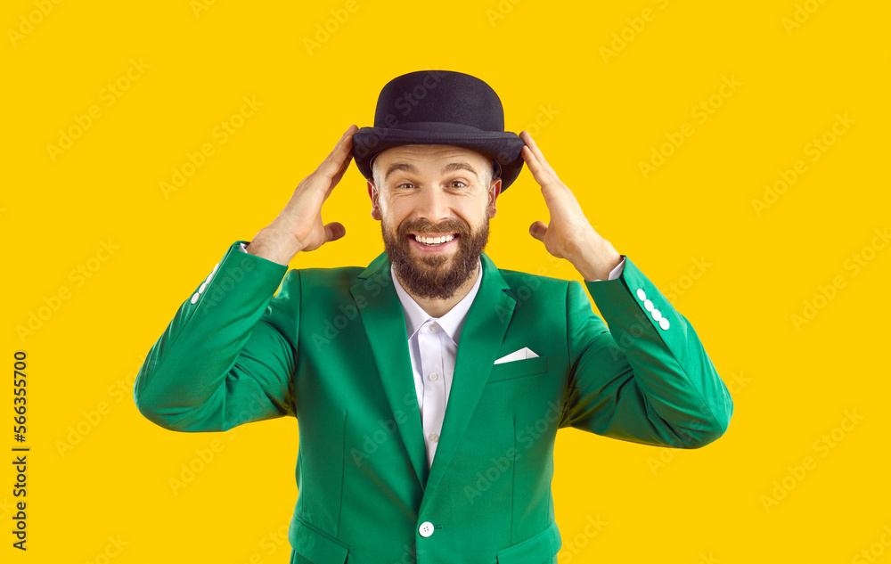 Portrait of cheerful smiling man in green jacket and black hat on orange background. Happy bearded man in stylish fashion suit celebrating St. Patrick's Day and smiling looking at camera. Portrait of cheerful smiling man in green jacket and black hat on orange background. Happy bearded man in stylish fashion suit celebrating St. Patrick's Day and smiling looking at camera.