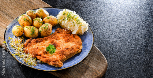 Pork cutlet coated with breadcrumbs with potatoes and cabbage