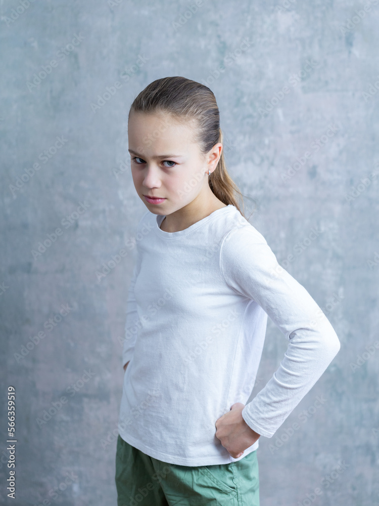 Selective focus medium vertical portrait of cute little blond angry little girl with hands on hips and attitude Selective focus medium vertical portrait of cute little blond angry little girl with hands on hips and attitude