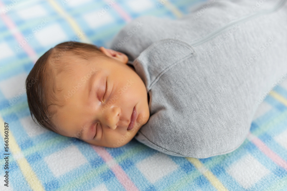 The baby is lying in a cocoon on cot. He sleeps sweetly and dreams. The baby is lying in a cocoon on cot. He sleeps sweetly and dreams.