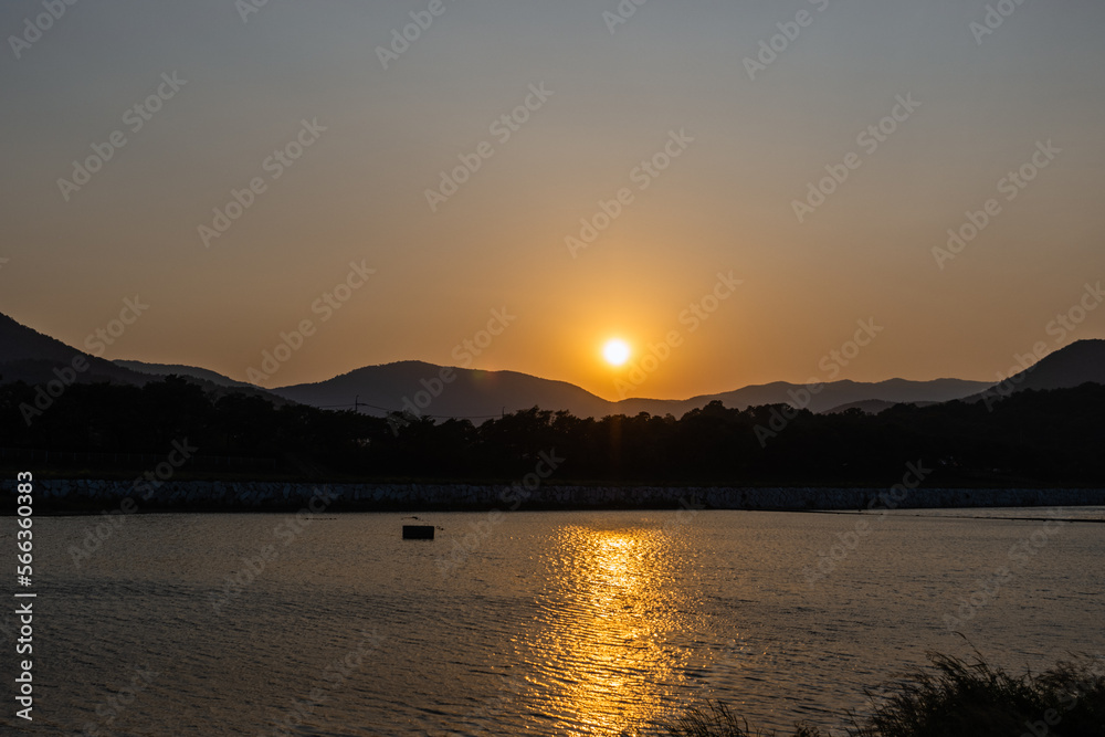 Sunset Behind the Mountains Next to a River Sunset Behind the Mountains Next to a River