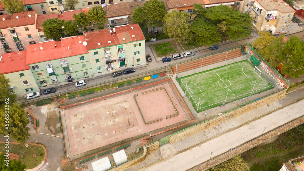 Fototapeta premium Aerial view of a soccer field among the buildings of an Italian periphery.