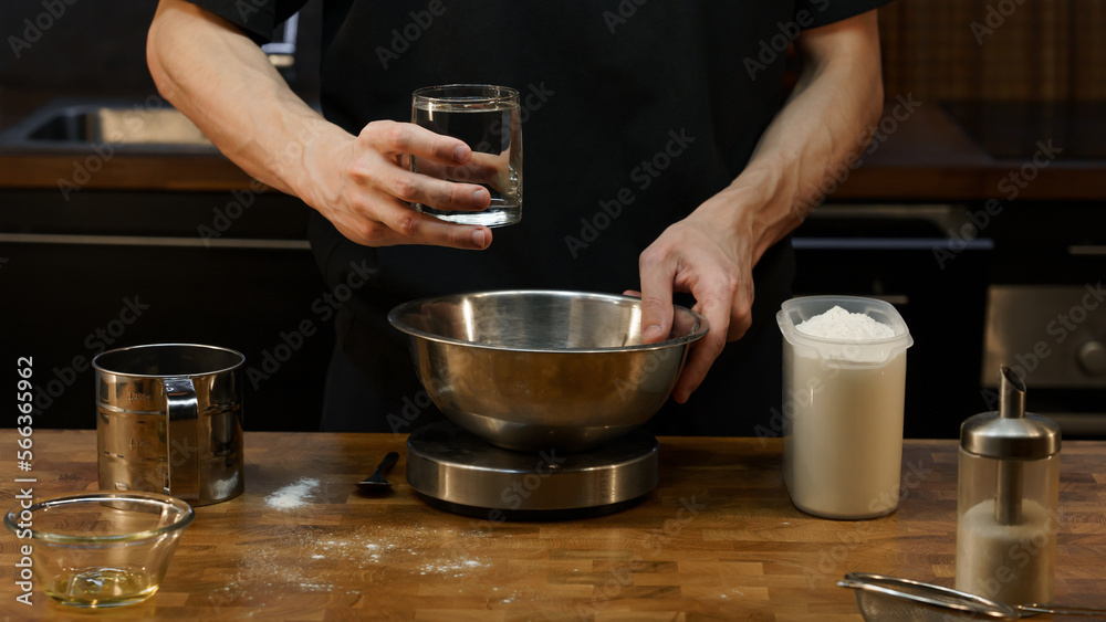 Young man cook kneads pizza dough. Hands close up, unrecognizable man, dark key Young man cook kneads pizza dough. Hands close up, unrecognizable man, dark key