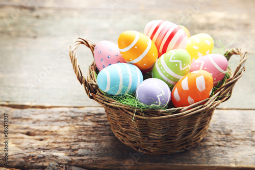 Obraz na płótnie Colorful eggs in basket on wooden background. Easter day concept w salonie