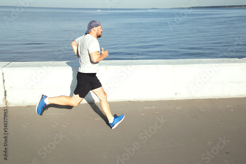 Athlete's morning running workout on the embankment © Алексей Васильев
