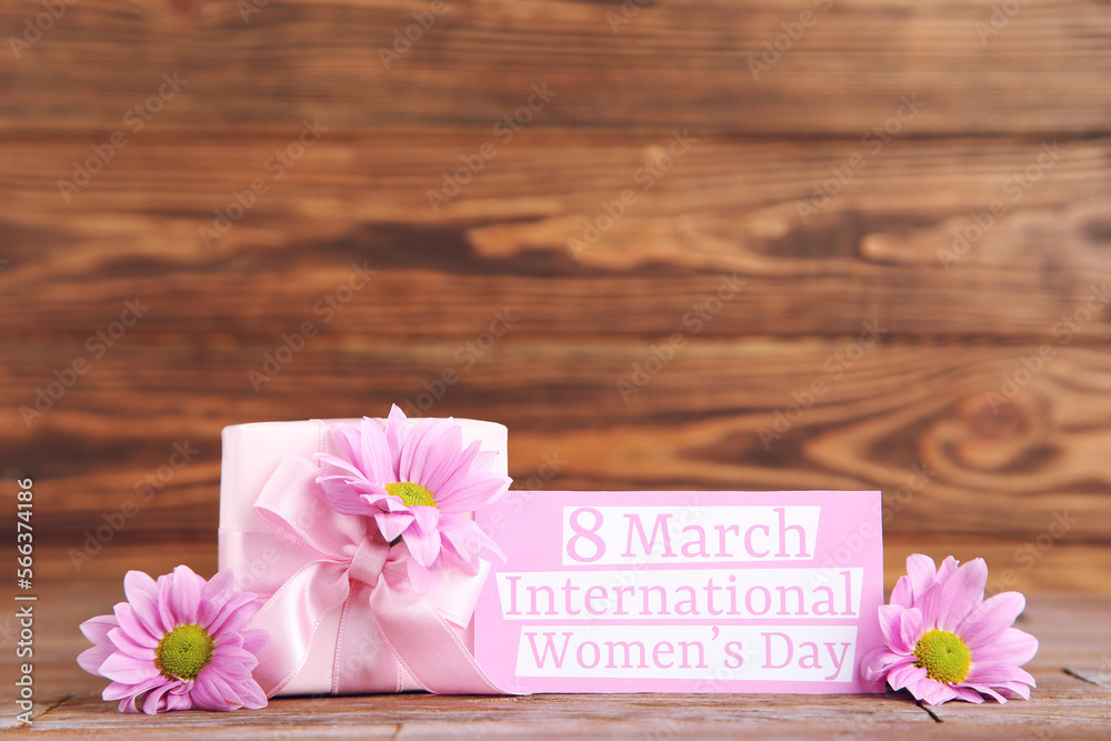 Fototapeta premium Flowers of chrysanthemums, gift and card with text 8 march International Women's Day on brown wooden background