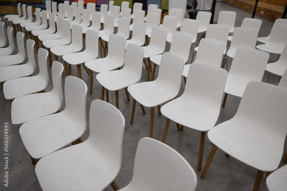 Naklejka premium Empty white plastic chairs in a conference room. 