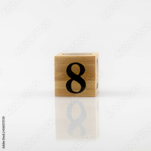 number 8 eight Wooden cube with number isolated in white with reflections. Numeral cubes with numbers..