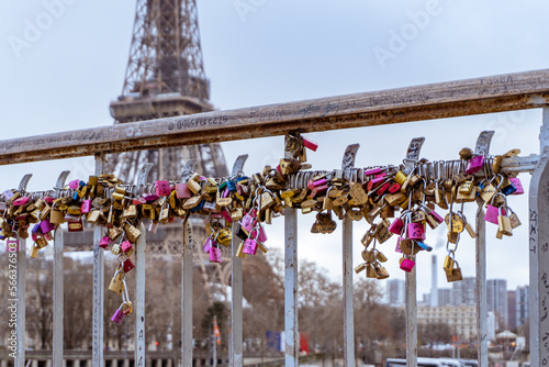 Fototapeta Naklejka Na Ścianę i Meble -  Love locks line the railings of the Debilly Footbridge, a pedestrian bridge crossing the Seine river near the Eiffel Tower.