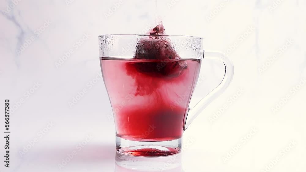 Tea bag infused in water for a hot tea. Making a tea in a transparent cup. Healthy drinking concept. Slow motion Tea bag infused in water for a hot tea. Making a tea in a transparent cup. Healthy drinking concept. Slow motion