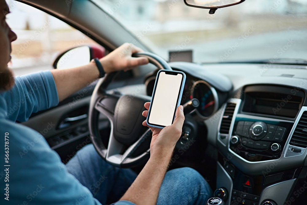 Naklejka premium Screen blank mockup mobile phone in the hands of a man driver in a car