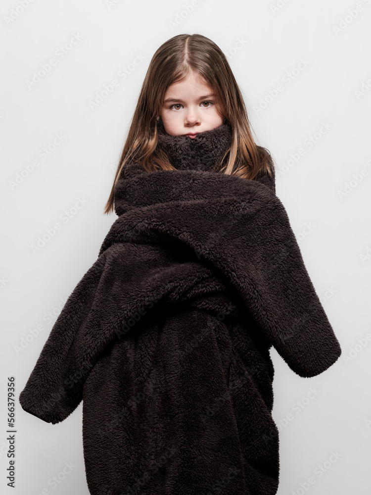 Une petite fille qui pose pour un portrait mode de vêtement trop grand pour elle Une petite fille qui pose pour un portrait mode de vêtement trop grand pour elle