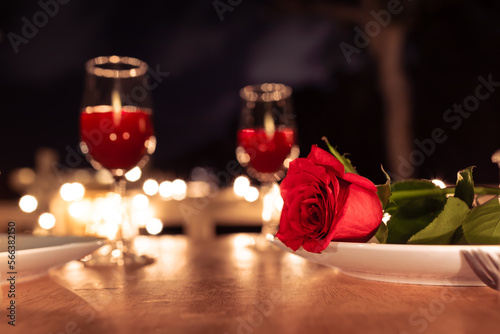 Glass of wine with rose for romantic dinner atmosphere 