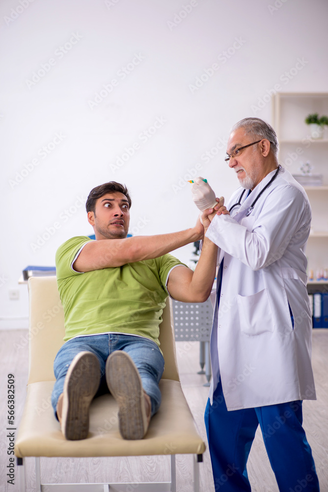Fototapeta premium Young male patient visiting old male doctor in vaccination conce