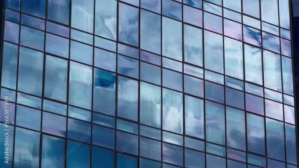 Modern office building facade. Tall business center with a glass facade. Construction of a glass facade structure. The glare of the sun on the glass wall of a skyscraper Modern office building facade. Tall business center with a glass facade. Construction of a glass facade structure. The glare of the sun on the glass wall of a skyscraper