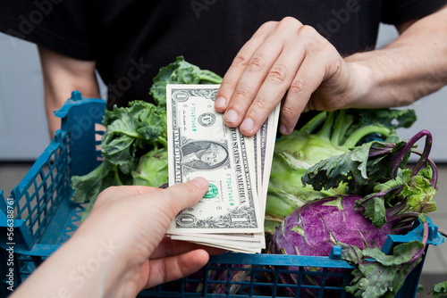 buyer of fresh vegetables pays merchant in cash dollars.... photo