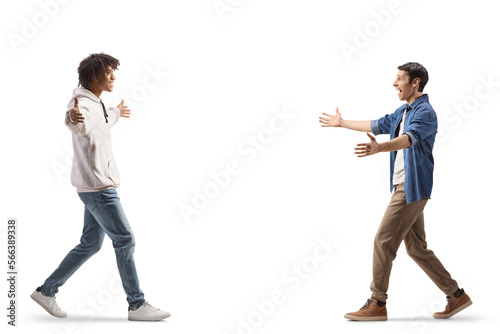 African american young man walking and greeting a caucasian male friend