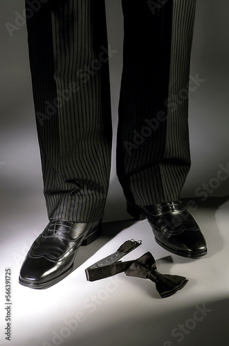 Man legs in dress pants, bow tie and elegant shoes, tuxedo, elegance concept