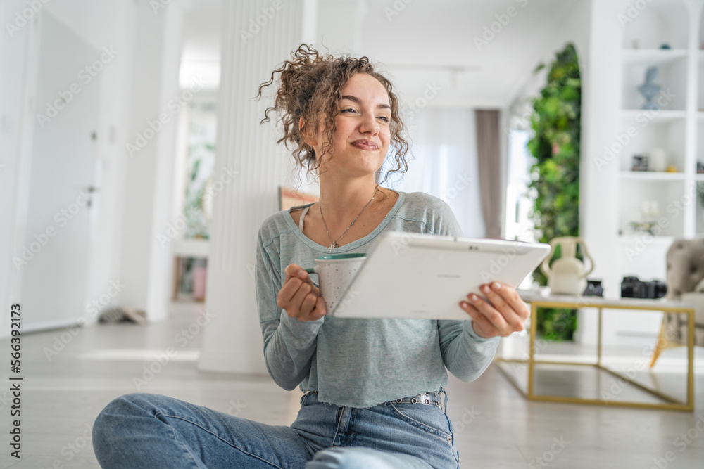 One woman young caucasian use digital tablet on the floor at home One woman young caucasian use digital tablet on the floor at home