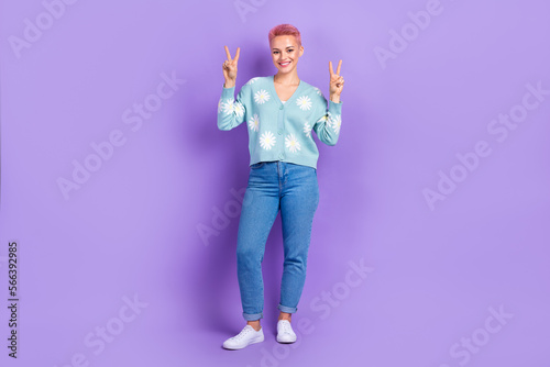 Full length photo of cheerful pretty woman wear blue cardigan daisy print show v-sign hello peace symbol isolated on violet color background © deagreez