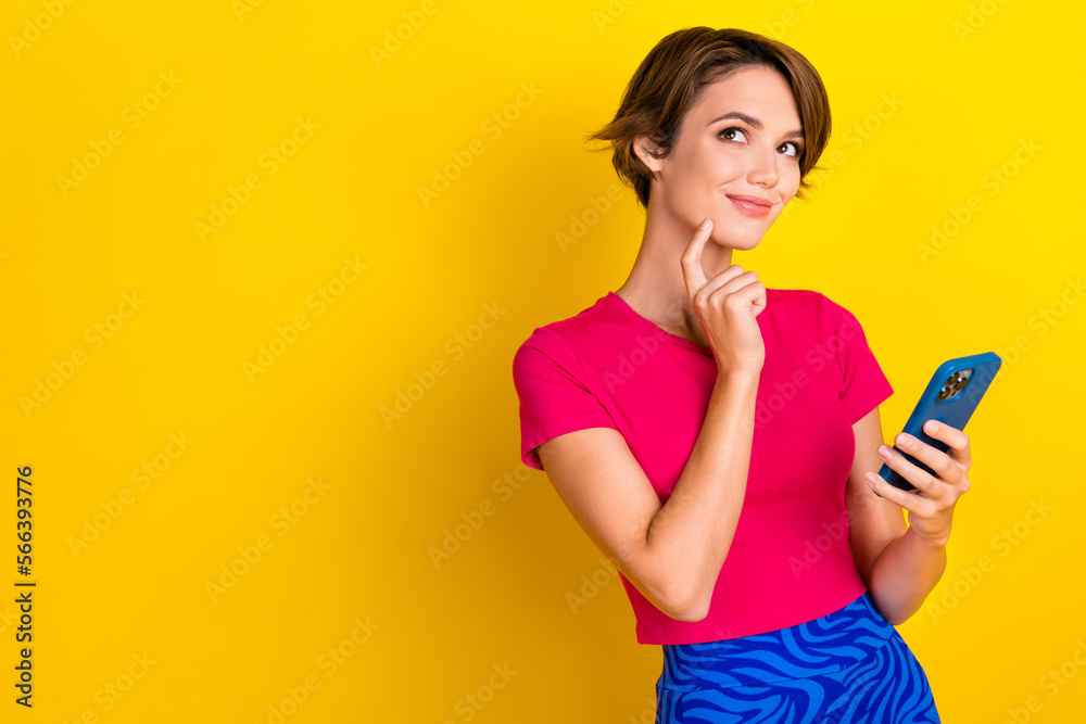 Photo of dreamy sweet woman dressed pink t-shirt finger chin chatting modern gadget empty space isolated yellow color background Photo of dreamy sweet woman dressed pink t-shirt finger chin chatting modern gadget empty space isolated yellow color background