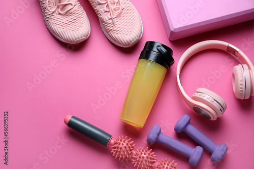 Fototapeta Naklejka Na Ścianę i Meble -  Sports water bottle with equipment, headphones and sneakers on pink background