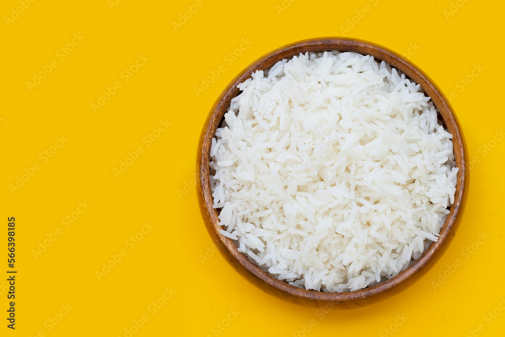 Wooden bowl of rice on yellow background. Wooden bowl of rice on yellow background.