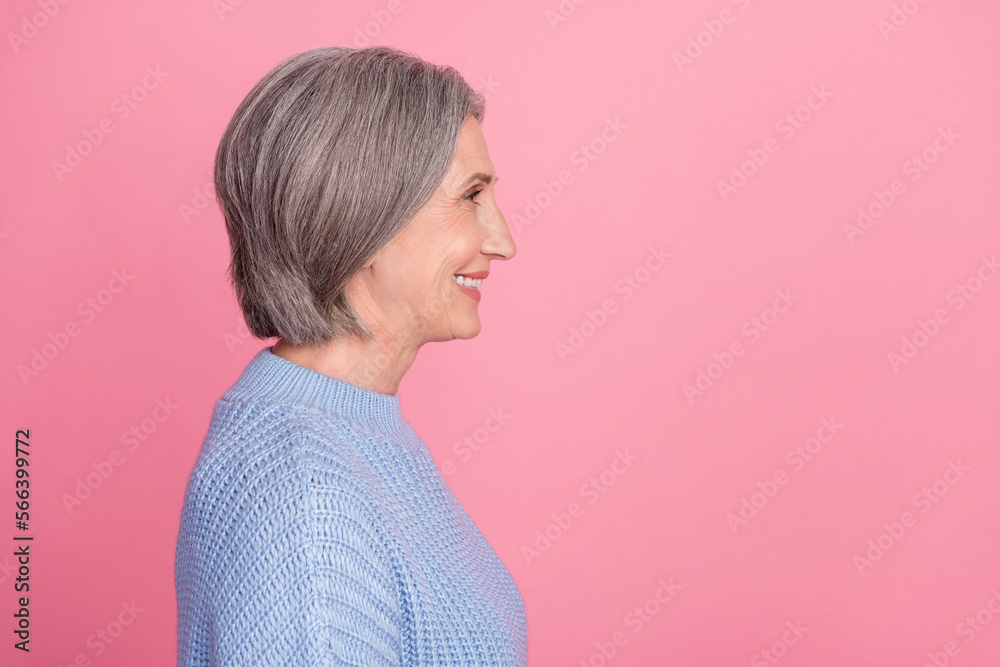 Side profile photo of mature aged old senior cheerful grandmother woman gray hair smiling looking empty space ad isolated on pink color background Side profile photo of mature aged old senior cheerful grandmother woman gray hair smiling looking empty space ad isolated on pink color background
