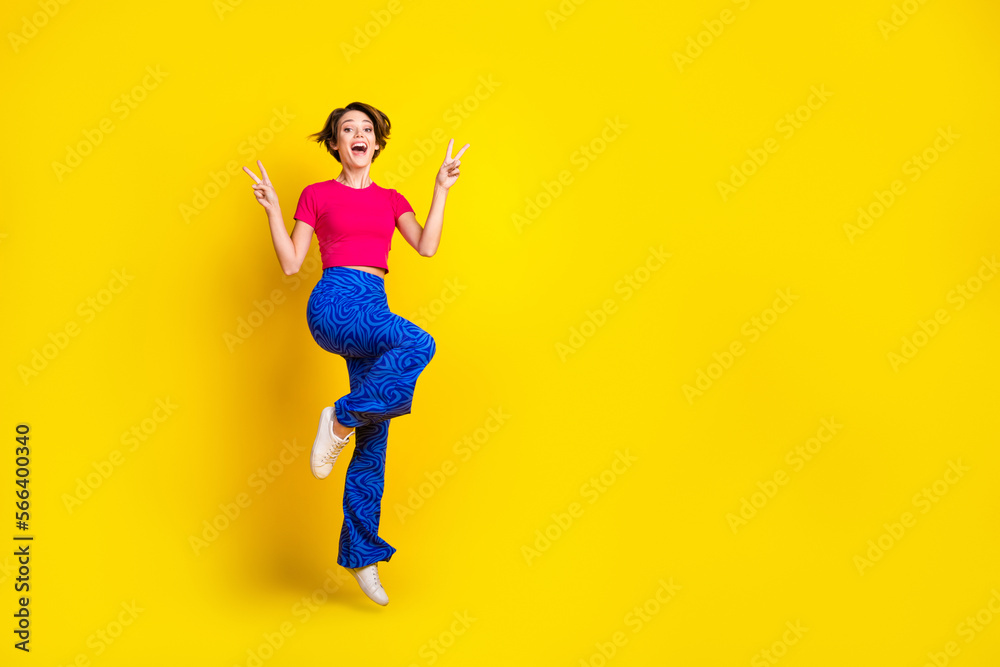 Full length photo of overjoyed positive lady wear stylish clothes arm demonstrate v-sign empty space isolated on yellow color background