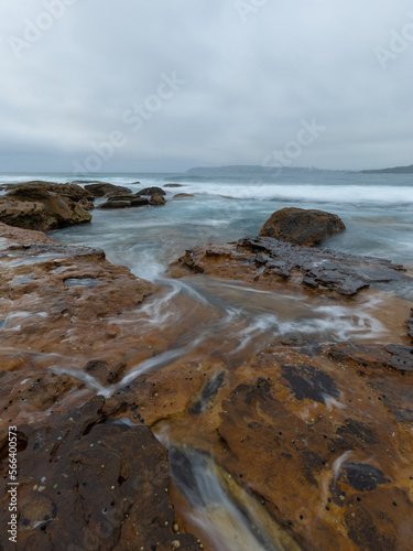 Wave water flowing on the rocky coastline.