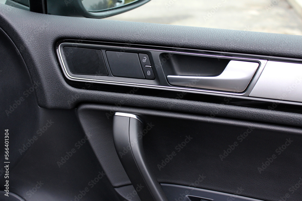 Passenger Door handle with lock controls button and adjustments in modern car. Driver door trim modern car.