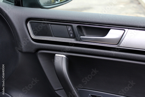 Passenger Door handle with lock controls button and adjustments in modern car. Driver door trim modern car.