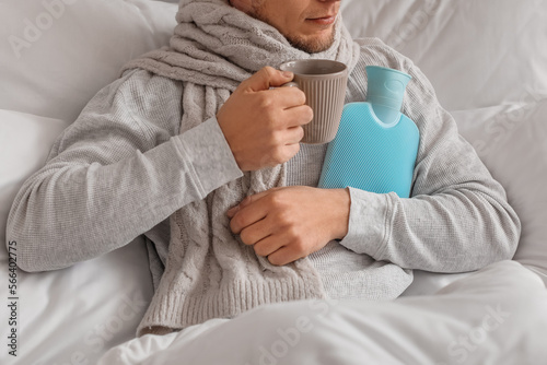 Ill man with cup of tea and...