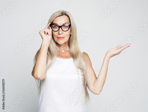 Smile senior woman wearing yellow sweater holding something on open palm