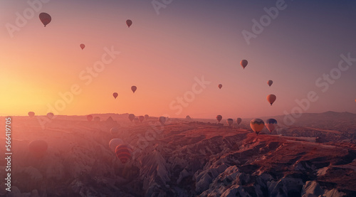 Amazing Panoramic view sunrise rocky landscape in Cappadocia with colorful hot air balloon deep canyons, valleys. Concept banner travel Turkey