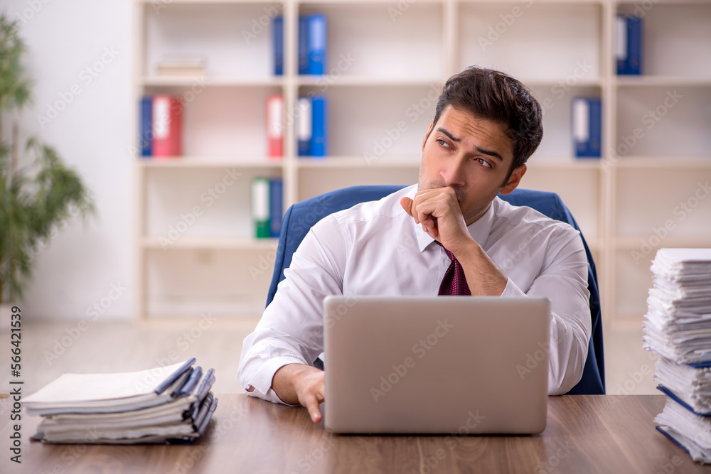 Young male employee and too much work in the office Young male employee and too much work in the office