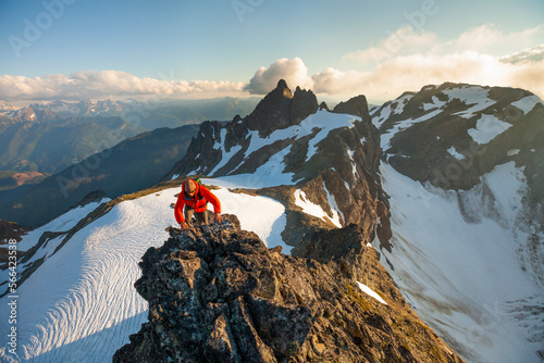 A climber scrambles up a rocky mountain ridge en route Stewart Peak in British Columbia, Canada. photo