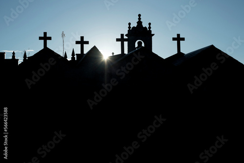 The sun peaks over a church and graveyard in Galicia, Spain on the Camino Primitivo, one route of the Camino de Santiago. photo