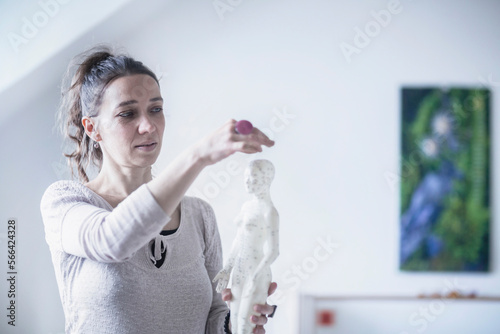 Female acupuncturist applying needles on acupuncture model, Freiburg im Breisgau, Baden-Württemberg, Germany