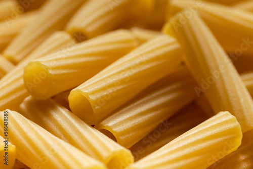 Uncooked dry rigatoni pasta. Food background. Closeup of noodles