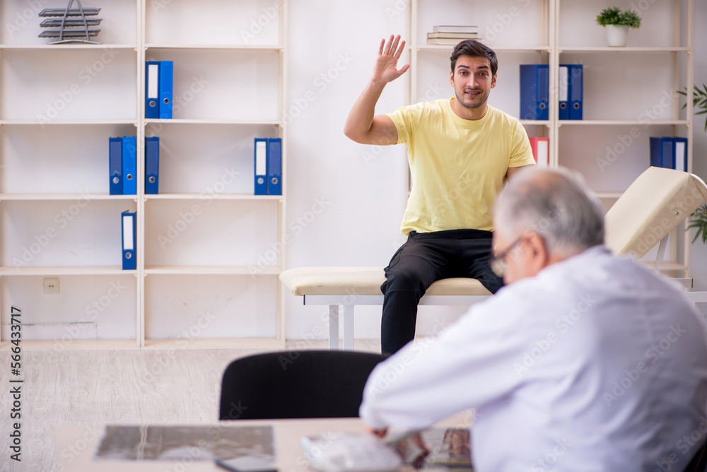 Young male patient visiting old male doctor Young male patient visiting old male doctor