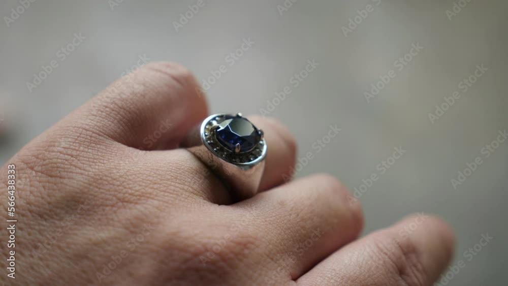 Blue stone silver ring on finger, close up Blue stone silver ring on finger, close up