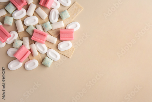 Many different chewing gums on beige background, flat lay. Space for text