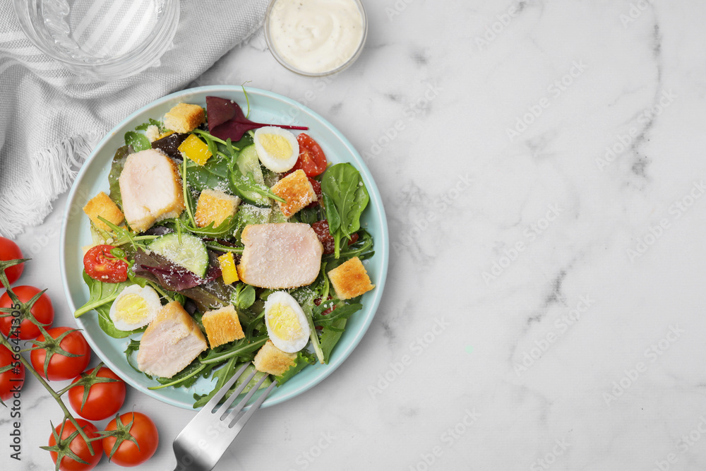 Delicious salad with croutons, chicken and eggs served on white marble table, flat lay. Space for text
